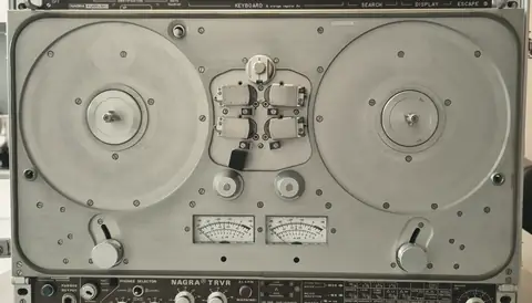 A portable reel-to-reel field recorder with two small meters.